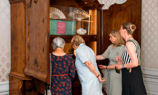 Bezoeker bekijken oude kast die tot vitrine is gemaakt. 