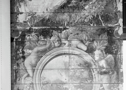 Het bewaard gebleven fragment van de zeventiende-eeuwse wandbetimmering, met putti en festoenen.