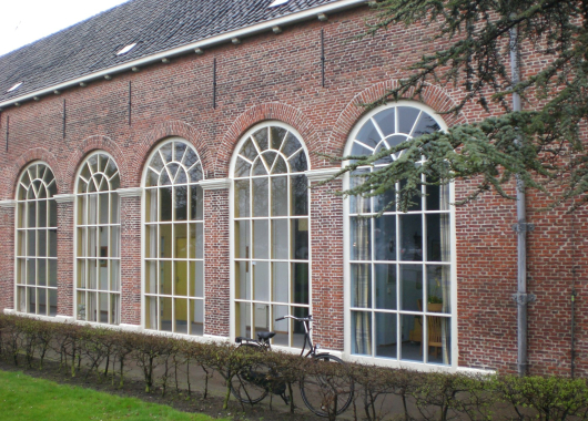 De voormalige tuingalerij, in de zeventiende eeuw nog open met vijftien bogen. Achter de later dichtgemaakte bogen zijn nu meerdere woningen.