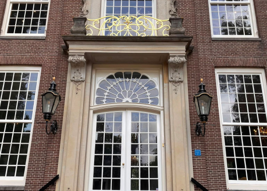De vooringang van Sparrendaal met boven de deur het pauwenvenster en daarboven het vergulde balkonhek.