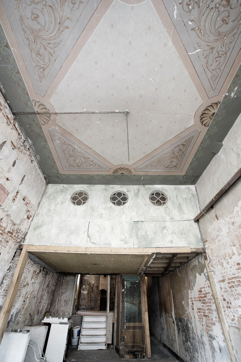 De winkelruimte vóór de restauratie, toen veel historische details nog verborgen of aangetast waren.
