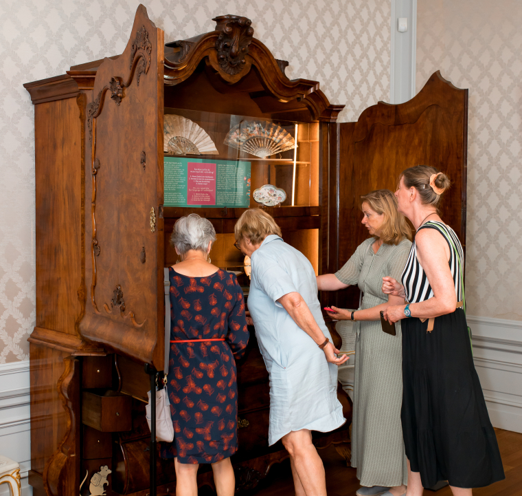 Bezoeker bekijken oude kast die tot vitrine is gemaakt. 