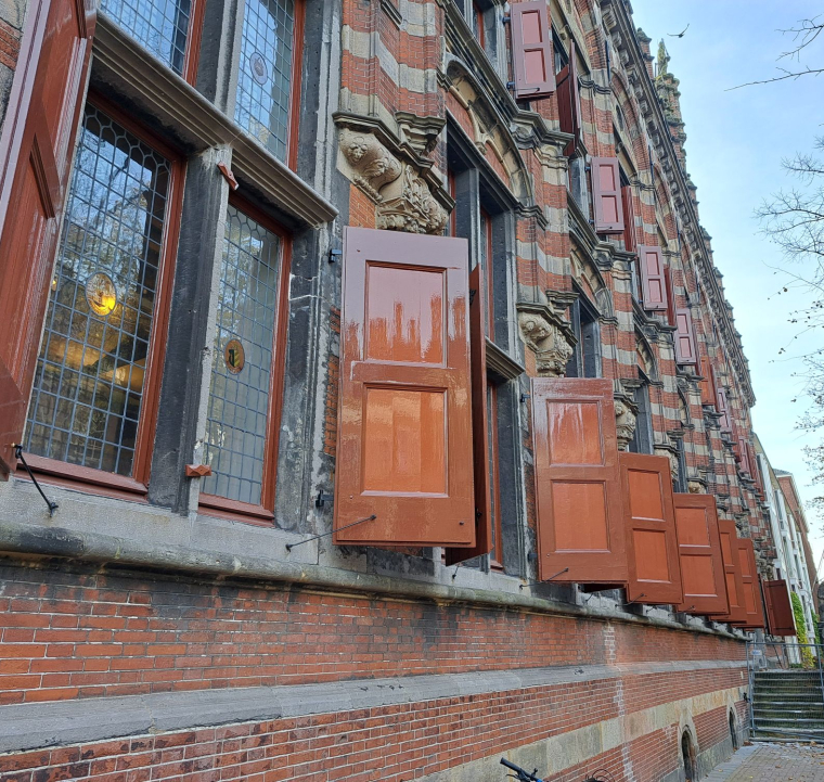 De gerestaureerde voorgevel met de teruggebrachte roodbruine luiken in historische kleurstelling. 